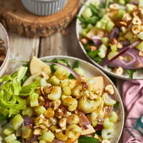 Two servings of Apple and Celery Salad with Toasted Hazelnuts served on chilled plates