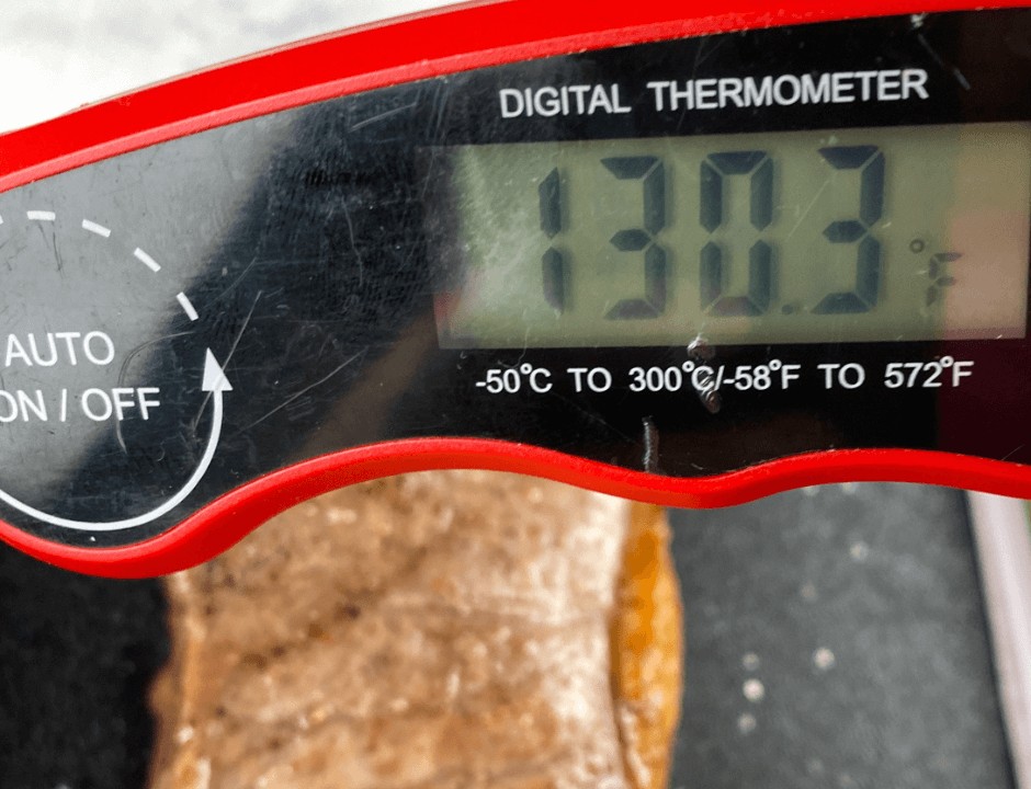 Using a meat thermometer to check the steak's internal temperature