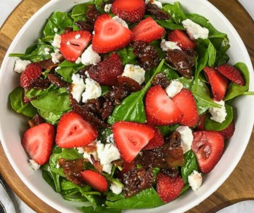 Classic Salad with Spinach and Warm Bacon Dressing served on a white bowl