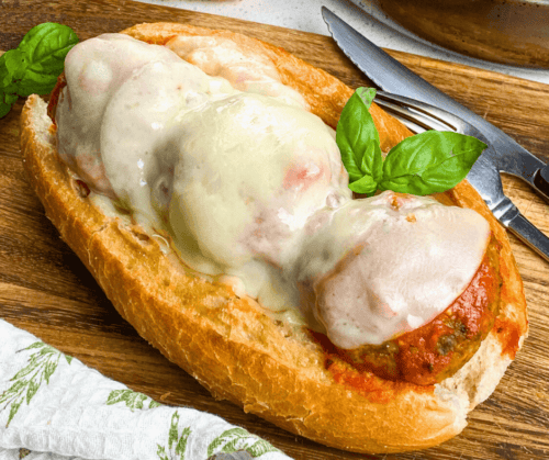 Easy Homemade Cheese-Stuffed Meatball Subs served on a wooden platter