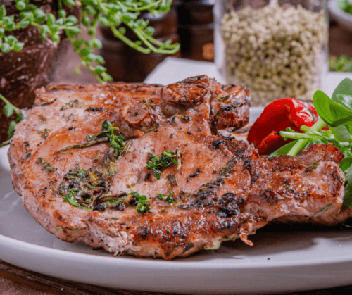 Marinated Grilled Pork Chop served on a white plate