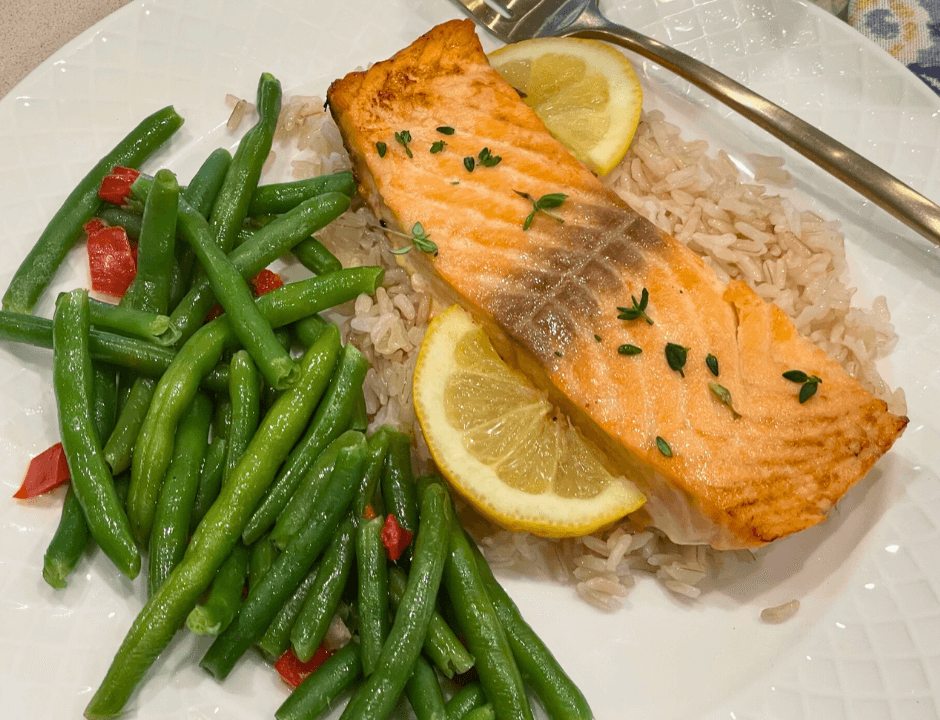 A plate of Lemon Butter Garlic Salmon with baked or lightly roasted green beans on the side