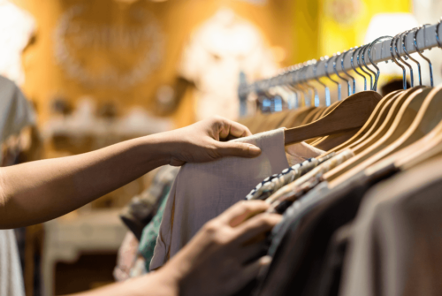 A woman browsing clothes on a rack in a store