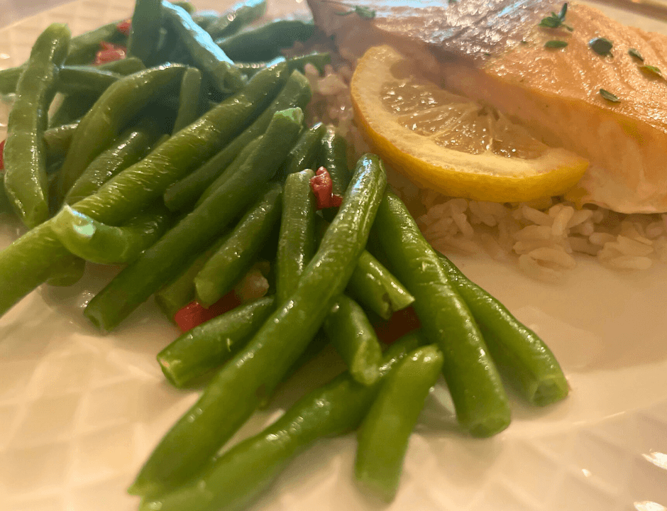 Baked or roasted green beans served as a side for Lemon Butter Garlic Salmon