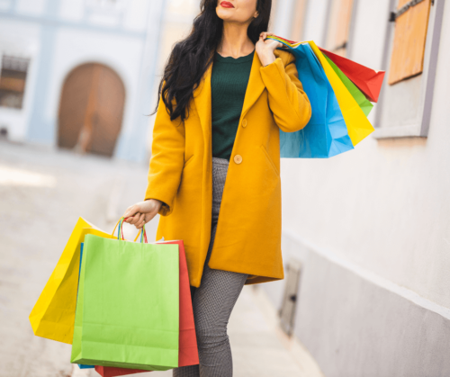 A woman holding multiple shopping bags - Designer Deals and Steals