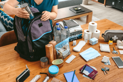 A woman preparing a backpack of car emergency kit