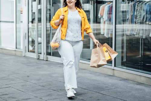 A plus size woman holding shopping bags