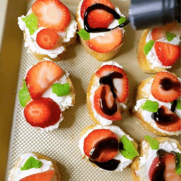 Adding balsamic glaze to the Easiest Strawberry Goat Cheese Crostini Appetizer