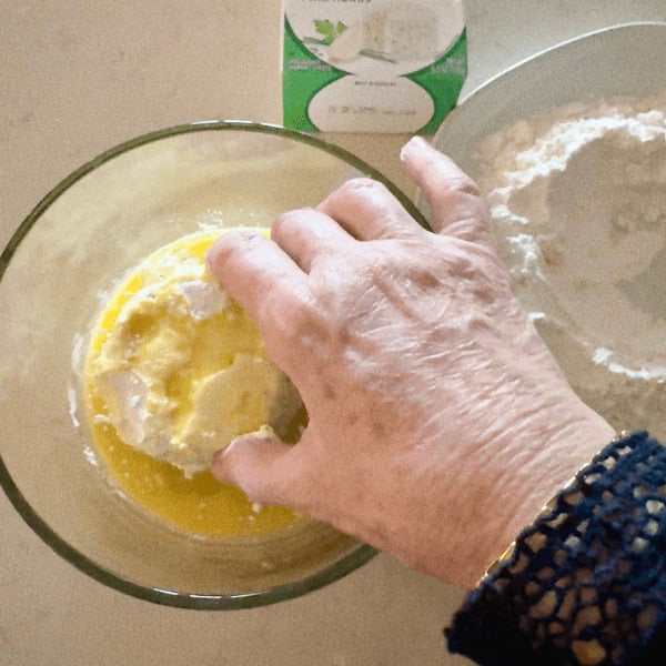 Lori dipping the flour-coated Boursin cheese into an egg
