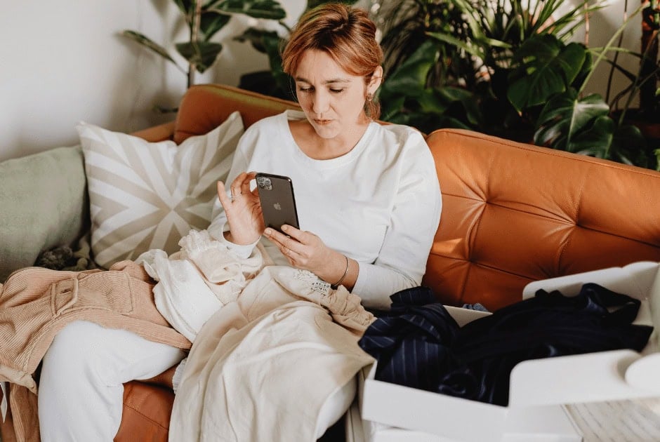 A woman using her phone - Where To Sell Used Clothes Online