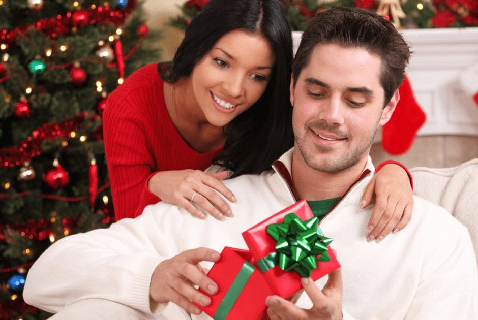 A man opening his gift in a red box - What To Buy For The Man Who Has Everything