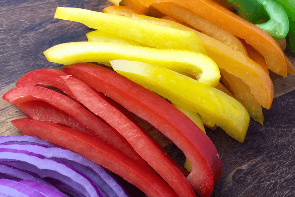 Cut colorful bell peppers and onion for No-Fuss Rotisserie Chicken Fajitas recipe